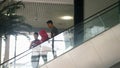 Thailand, Krabi, 13 july 2018. People with travelling suitcases riding down on escalator, airport arrival.