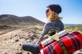 People and trekking backpack travel adventure activity - blonde woman sit down and rest looking at the beautiful scenic landscape