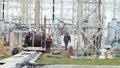 People turn bobbin and uncoil wire at substation site