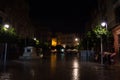People with Umbrellas during a Rainy Spanish Night in Seville, S