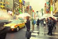 People with umbrellas under the rain in the bustling neighborhood of Shinjuku, Tokyo Royalty Free Stock Photo