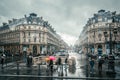 People under colored umbrellas run in the rain on the streets of Paris, France Royalty Free Stock Photo