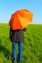 People under an orange umbrella in a field Royalty Free Stock Photo