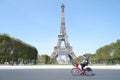 People using bicycle across Eiffel Tower in Paris clear sky