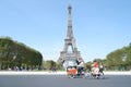 People using bicycle across Eiffel Tower in Paris clear sky