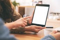 People using, looking and pointing at the same mockup tablet pc on wooden table Royalty Free Stock Photo