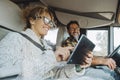 People using tablet device during travel vacation inside camper van. Technology roaming connection. Choosing next destination