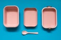 Empty pink bento lunch box with spoon on blue background Royalty Free Stock Photo