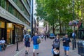 Villiers Street in London features pedestrians strolling along a brick-paved path lined with shops, including a Starbucks Royalty Free Stock Photo