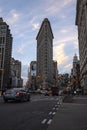 People and vehicles on the morning peak street around Flatiron Building during sunrise