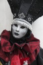 Person at Venice Carnival dressed in a black and red venetian costume and venetian mask Venice Italy Royalty Free Stock Photo