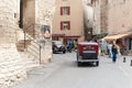 People and vintage cars in street in ancient French hilltop village Royalty Free Stock Photo