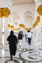 People visit Sheikh Zayed Grand Mosque. Traditionally dressed tourist woman with black burka visiting Mosque Abu Dhabi Royalty Free Stock Photo