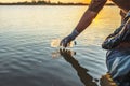 Ã Â¸Å¸people volunteer keeping garbage plastic bottle into black bag on river in sunset