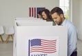 People voting standing in a row at polling station at vote center with usa flags. Royalty Free Stock Photo