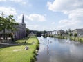 People wade in river ourthe near centre of Hotton in the belgian ardennes on warm summer day