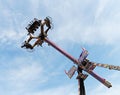 People wait up in the blue sky for the vertical ride and the zero gravity thrill at an amusement park