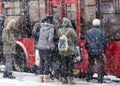 People waiting for public transport at bus stop in heavy blizzard in winter Royalty Free Stock Photo