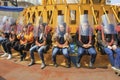 People waiting for start of experience with amazing speed on free falling tower attraction in amusement park ride. Royalty Free Stock Photo