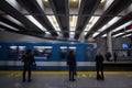 People waiting for a subway in Berri-UQAM station platform, green line, while a metro train is coming