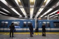 People waiting for a subway in Berri-UQAM station platform, green line, while a metro train is coming, with a speed blur