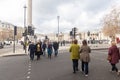 People waiting to cross the road next to Trafalgar Square, London, UK