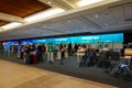 People waiting to get their tickets at an airline checkin counter at a busy airport