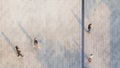 People walk on across the pedestrian concrete landscape with black silhouette shadow on ground top aerial view Royalty Free Stock Photo