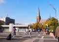 People walk across the station forecourt to the train station and to buses