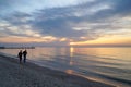 People walk along the Black Sea coast, meeting the dawn. Royalty Free Stock Photo