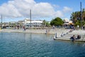 People walk along harbor edge Tauranga city waterfront playground and The Strand background. Royalty Free Stock Photo