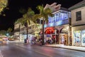 People walk along the main street in Key West with shops at night. The scenic Main street is the touristic main shopping area for