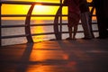 People walk along the promenade in the yellow and orange rays of the sun at sunset. Royalty Free Stock Photo