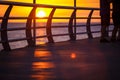 People walk along the promenade in the yellow and orange rays of the sun at sunset. Royalty Free Stock Photo