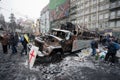 People walk around the barricades with burned out