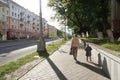 People walk through city. Mother going with dauthter along the street. City life