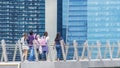 People walk in city pedestrian bridge with exterior modern build