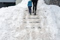 People walk by concrete stone staircase covered dirty deep slippery snow after blizzard snowstorm snowfall at city Royalty Free Stock Photo