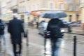 People walk down the street in rain. blurred focus