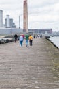 People walk on hte great south walk at Pollbeg lighthouse.