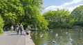 People walk leisurely around lake in public park of St. Stephens Green in city