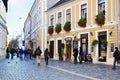 People walk on a narrow street with cobblestone pavers in the old historic town center