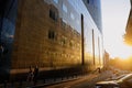 People walk near a tall glass office building at twilight in the old center of Bucharest Royalty Free Stock Photo