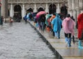people walk over the elevated walkway during high tide in Venice Royalty Free Stock Photo