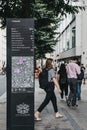 People walk past directions and map board on Cheapside, City of London, UK. Royalty Free Stock Photo