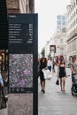 People walk past directions and map board on Poultry, City of London, UK. Royalty Free Stock Photo