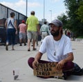 People walk past homeless veteran