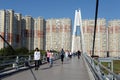 People walk on the Pavshinsky pedestrian bridge over the Moscow river in Krasnogorsk near Moscow