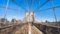 People walk and ride bicycle on Brooklyn bridge in New York City, sunny day. United states tourism landmark, American city life