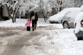 People walk on a very snowy sidewalk. People step on an snow-stray pathway. Icy sidewalk. Ice on sidewalks